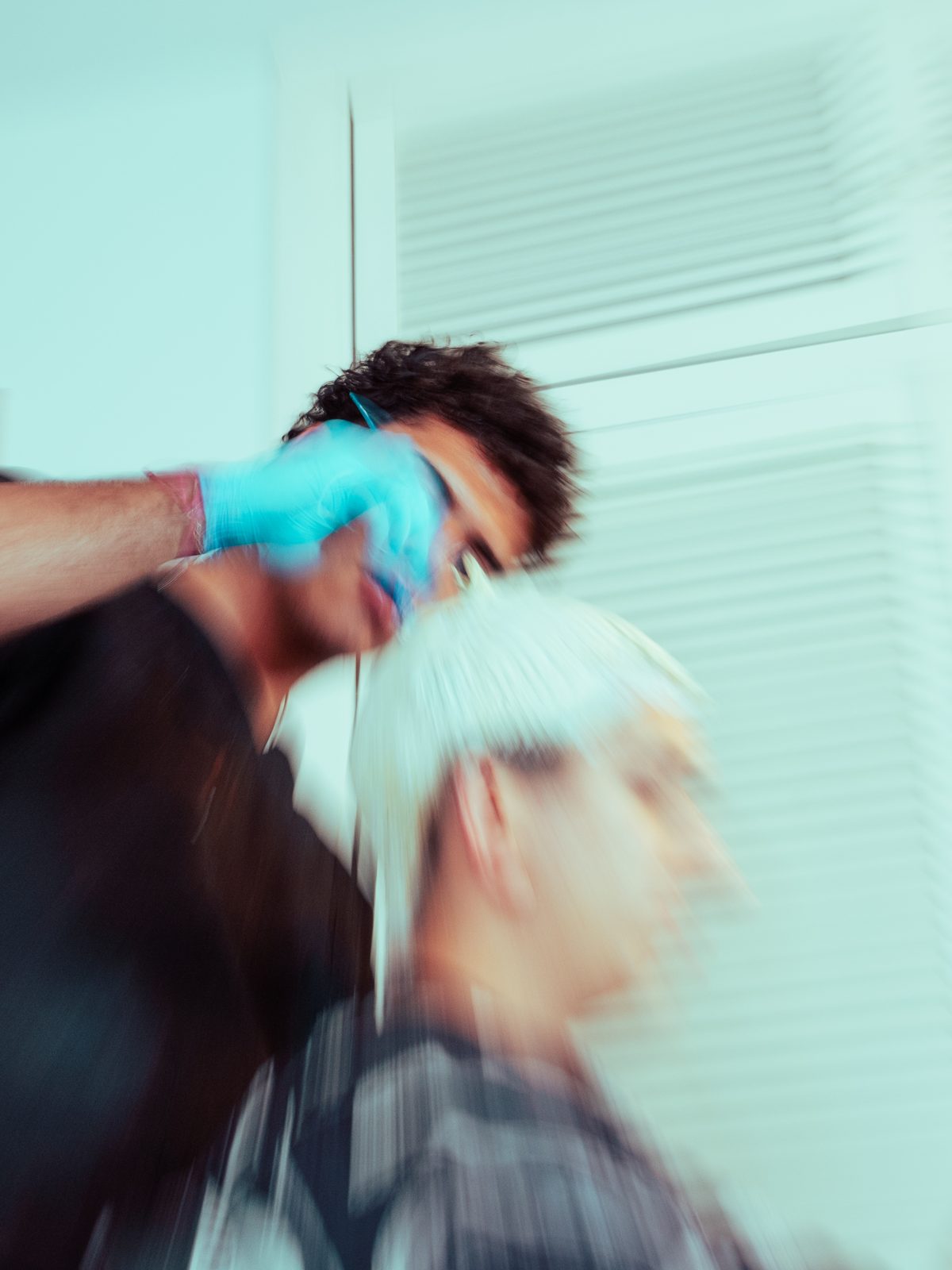 Barbero con guantes cortando el pelo
