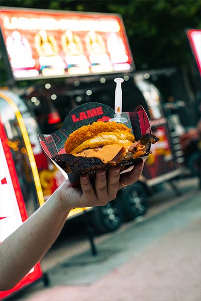 Hamburguesa ante el food truck iluminado